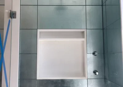 Custom tiled walk-in shower with rainfall showerhead and built-in wall niche